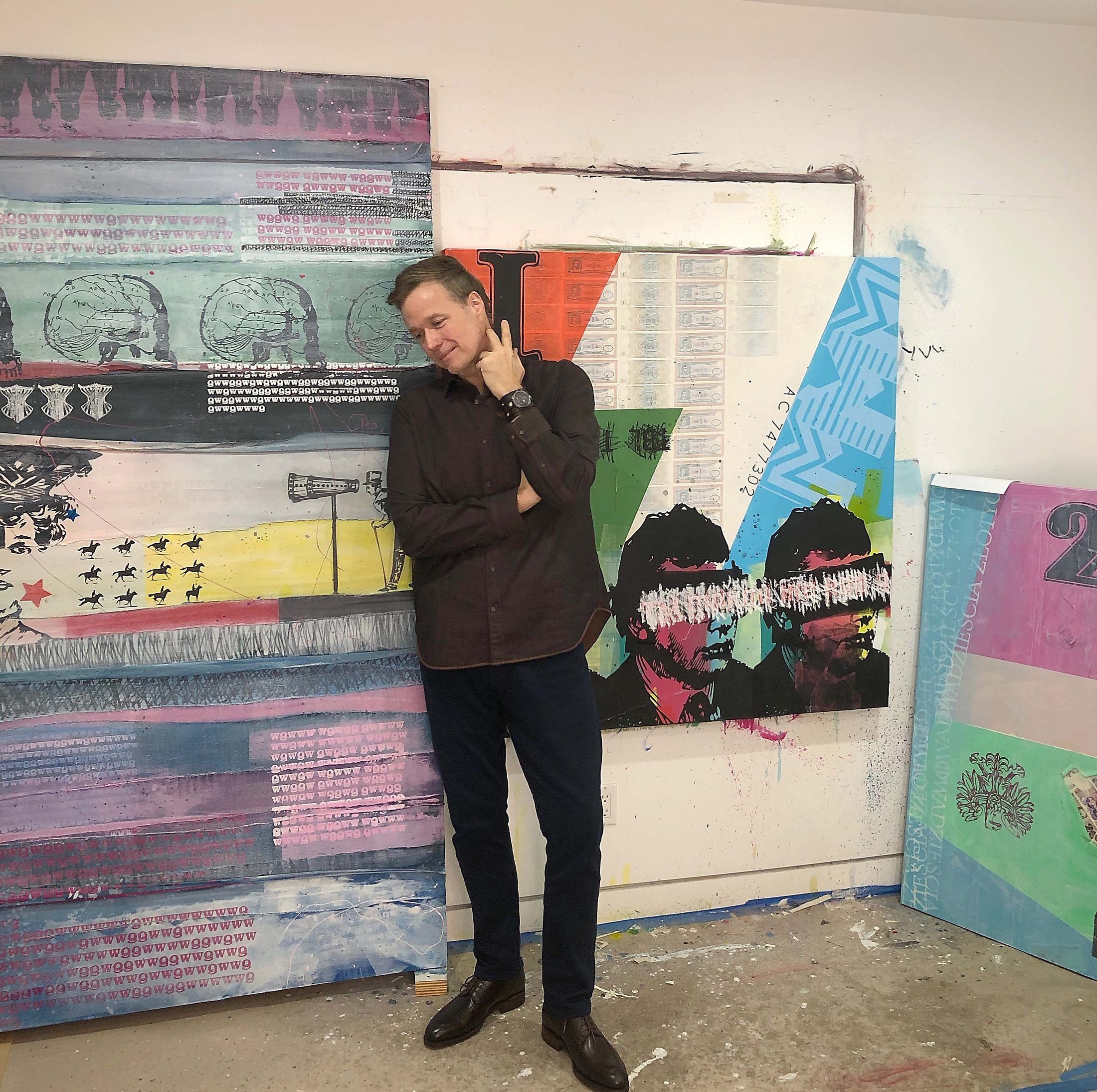 Brian Drake in his Los Angeles studio, standing between large Broken Banknote paintings